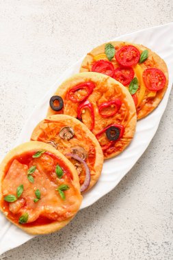 Beyaz arka planda farklı lezzetli pizzalar olan tabaklar.