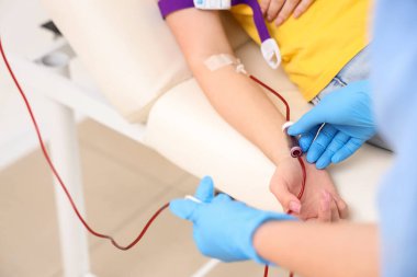 Klinikte genç donörden kan alan kadın hemşire, yakın plan.