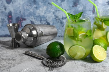 Bir bardak soğuk mojito ve sallanan limonlu mavi masa.