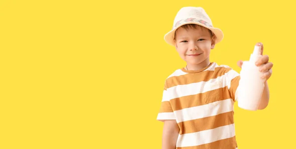 テキストのためのスペースと黄色の背景に日焼け止めクリームと小さな男の子 — ストック写真
