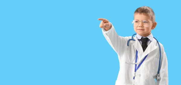 Cute Little Doctor Pointing Something Light Blue Background Space Text — Stock Photo, Image