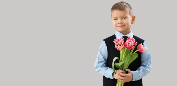 可愛いです男の子ともに花束の新鮮なチューリップ上の灰色の背景にスペースのためにテキスト — ストック写真
