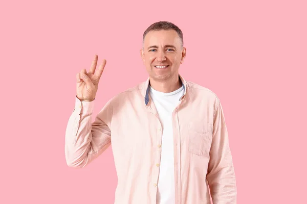 Mature Blood Donor Showing Victory Gesture Pink Background — Stock Photo, Image