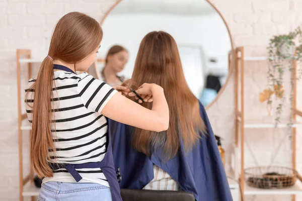 美容室で若い女性の髪を切断する女性の美容師 バックビュー — ストック写真