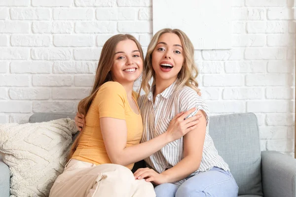 Mladé Sestry Objímají Doma Gauči — Stock fotografie