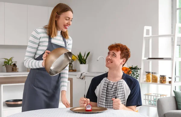 Young Woman Cloche Proposing Her Confused Boyfriend Kitchen — Stock Photo, Image