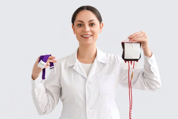 Médico Femenino Con Cinturón Elástico Paquete Sangre Sobre Fondo Claro — Foto de Stock