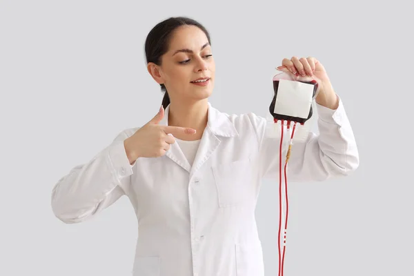Ärztin Zeigt Auf Blutkonserve Für Transfusionen Vor Hellem Hintergrund — Stockfoto