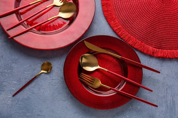 Goldenes Besteck Mit Roten Tellern Und Küchenmatte Auf Blauem Grunge — Stockfoto
