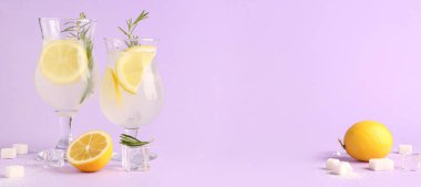 Taze limonata bardakları ve eflatun arka planda metinler için yeri olan malzemeler.