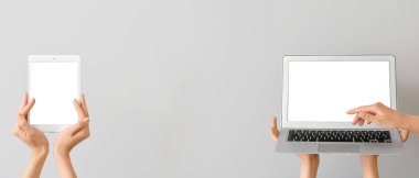 Kadın eli pankart, modern dizüstü bilgisayar ve gri arka planda tablet bilgisayar