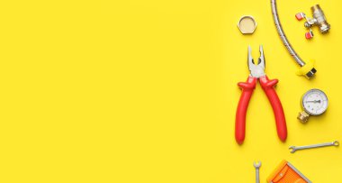 Sarı arka planda tesisatçı malzemeleri ve metin için yer var.