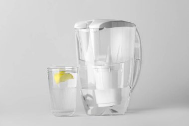 Su filtresi sürahi ve arkaplanda limon dilimi olan cam.