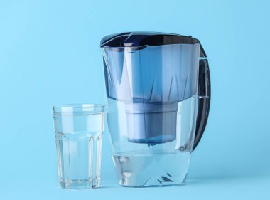 Mavi zemin üzerinde cam olan su filtresi sürahisi