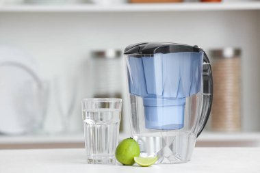 Mutfaktaki masada cam ve limonlu su filtresi.