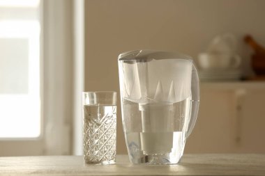 Su filtresi sürahi ve cam mutfak masasında.