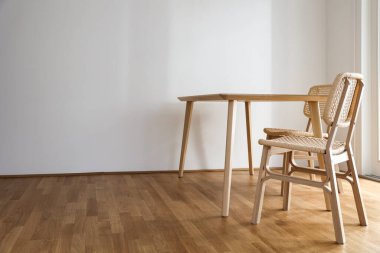 Lşık odasında hasır sandalyeli ahşap yemek masası.