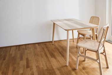 Lşık odasında hasır sandalyeli ahşap yemek masası.