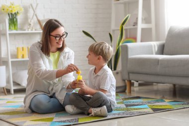 Evde sabun köpüğü üfleyen küçük çocukla dadı