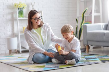 Evde sabun köpüğü üfleyen küçük çocukla dadı