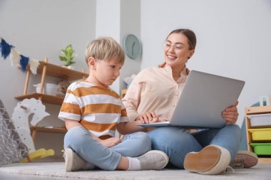 Evde çizgi film izleyen küçük çocukla dadı.