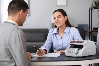 Ofiste müşteriyle çalışan kadın banka müdürü