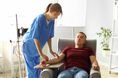 Klinikte olgun donörden kan alan kadın hemşire.