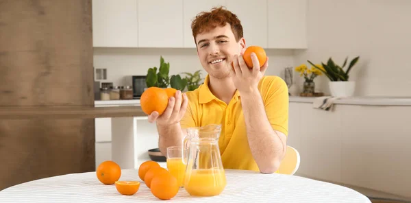 Gelukkige Jongeman Met Sinaasappels Sap Keuken — Stockfoto