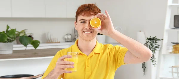 Szczęśliwy Młody Człowiek Szklanką Soku Pomarańczowego Kuchni — Zdjęcie stockowe