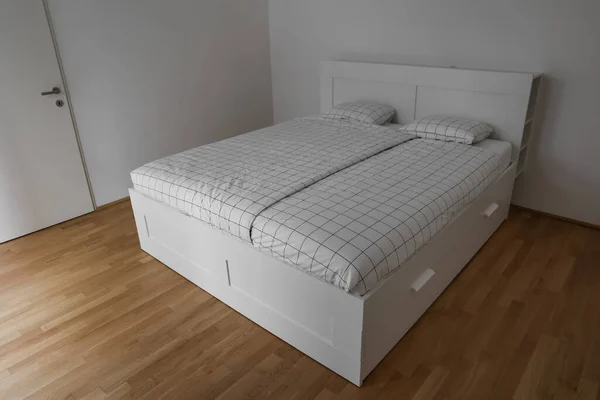 Modern Säng Med Lådor Nära Ljusvägg — Stockfoto
