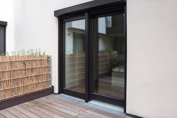 Вид на здание с большими окнами и черными жалюзи снаружи