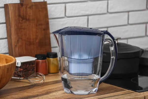 Water filter jug on kitchen counter near white brick wall