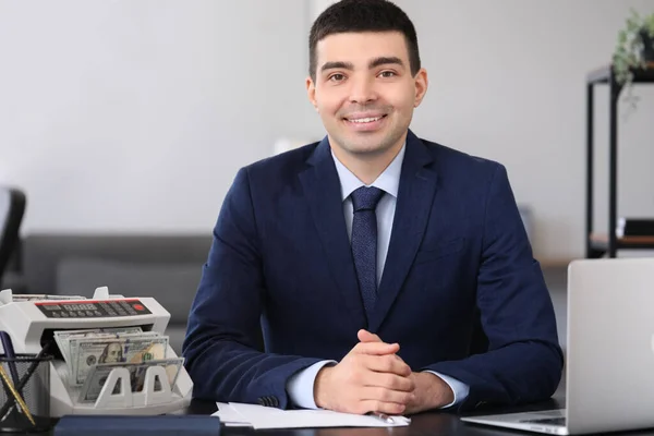 Stock image Male bank manager working with cash counting machine in office