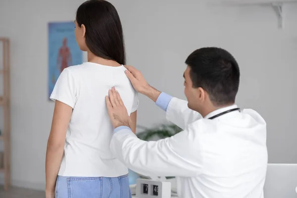 男医生检查年轻妇女在诊所的体位 — 图库照片