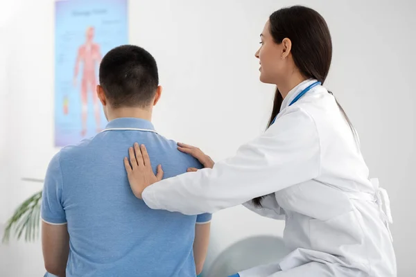 Medico Donna Che Controlla Postura Del Giovane Clinica — Foto Stock