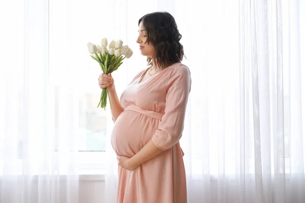 Młoda Kobieta Ciąży Tulipanami Pobliżu Okna Domu — Zdjęcie stockowe