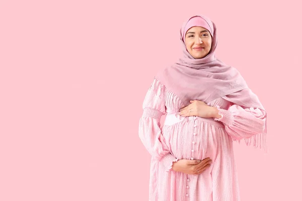 若いです妊娠中のイスラム教徒女性オンピンクの背景 — ストック写真