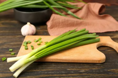 Ahşap zemin üzerinde taze yeşil soğan olan tahta.