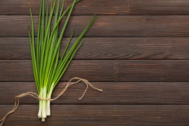 Ahşap zemin üzerinde taze soğan demeti