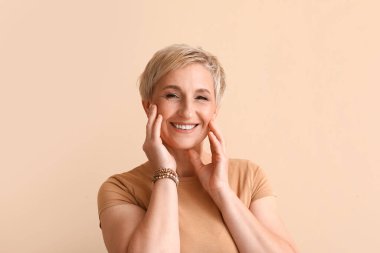 Mature blonde woman on beige background