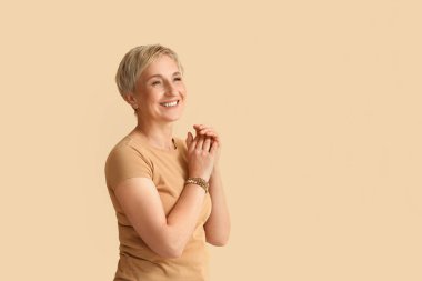 Mature blonde woman on beige background