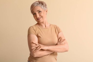 Mature blonde woman on beige background