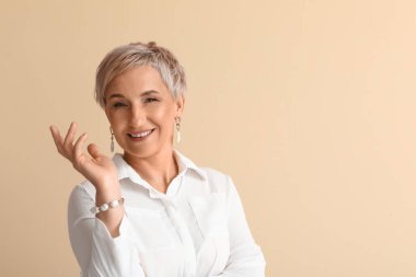Mature blonde woman on beige background