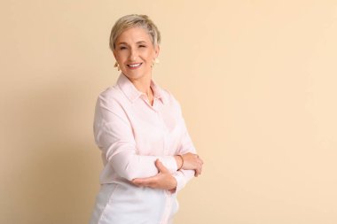 Mature blonde woman on beige background