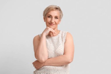 Mature blonde woman on light background