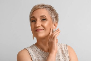 Açık arka planda olgun sarışın kadın, yakın plan.