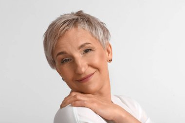 Açık arka planda olgun sarışın kadın, yakın plan.