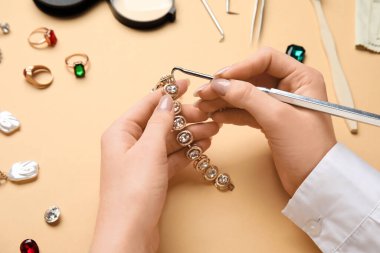 Renkli arka planda güzel bileziği temizleyen kadın, yakın plan.