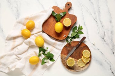 Beyaz masanın üzerinde açan dalları olan limon tahtaları.