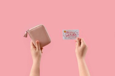 Cüzdanı ve pembe arka planda hediye kartı olan bir kadın.